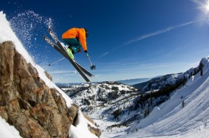 Alpine skier jumping over rocks