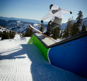 A Squaw skier enjoying time on the rails in the terrain park.